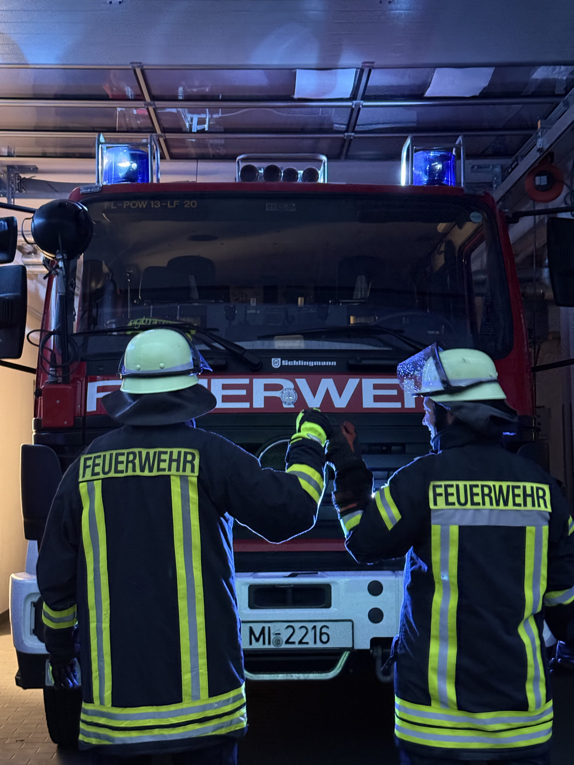 Zwei Personen vor einem Einsatzfahrzeug